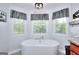 Luxurious bathroom with a standalone tub, modern fixtures, and ample natural light at 1621 Dixie Rd, Covington, GA 30014
