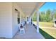 Covered front porch with white columns and rocking chairs overlooking a well-manicured lawn at 1621 Dixie Rd, Covington, GA 30014