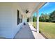 Long, covered front porch with white columns offering ample space for seating and relaxation at 1621 Dixie Rd, Covington, GA 30014