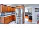 Modern kitchen with stainless steel refrigerator, granite countertops, and wood cabinets, with an adjacent living area at 1621 Dixie Rd, Covington, GA 30014