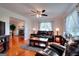 Cozy living room with hardwood floors, fireplace and plush black leather seating beneath a ceiling fan at 1621 Dixie Rd, Covington, GA 30014