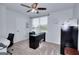 Bright home office with a dark desk and ceiling fan, offering a productive workspace at 1621 Dixie Rd, Covington, GA 30014