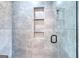 Modern tiled shower with glass door and built-in shelves, offering a sleek design at 1621 Dixie Rd, Covington, GA 30014