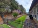 Backyard featuring synthetic grass, black metal fence, and beautiful flowering trees at 511 Bonneset Ct, Canton, GA 30114