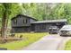 Charming two-story home with dark siding, a metal roof carport, and a well-maintained front lawn at 870 The Cir, Lawrenceville, GA 30043