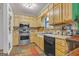 Outdated kitchen featuring appliances, oak cabinetry, an island, and countertops, ready for updates at 870 The Cir, Lawrenceville, GA 30043