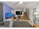 Living room with accent wall, large television, staircase, ceiling fan, and patterned rug at 870 The Cir, Lawrenceville, GA 30043