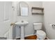 A half bathroom featuring a pedestal sink and wood shelving at 1363 Penhurst Dr, Lawrenceville, GA 30043