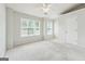 Well-lit bedroom with two windows, neutral carpet, and a ceiling fan at 1363 Penhurst Dr, Lawrenceville, GA 30043