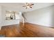 Open-concept living room with hardwood floors, a ceiling fan, and a view of the kitchen and staircase at 1363 Penhurst Dr, Lawrenceville, GA 30043