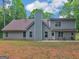 Spacious backyard featuring a two-story home with gray siding, a patio, and ample lawn space at 445 Royal St, Mcdonough, GA 30253