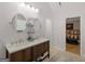 Bright bathroom features a double sink vanity, two round mirrors, and access to the main bedroom at 445 Royal St, Mcdonough, GA 30253