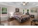 Bedroom features a ceiling fan, wood flooring, and natural light from many windows at 445 Royal St, Mcdonough, GA 30253