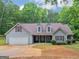 Charming single-story home features gray siding, brown roof and attached two-car garage at 445 Royal St, Mcdonough, GA 30253