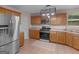 Kitchen featuring stainless steel appliances, tile floors, and wooden cabinetry at 445 Royal St, Mcdonough, GA 30253