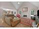 Spacious living room featuring vaulted ceiling, fireplace, and windows at 445 Royal St, Mcdonough, GA 30253