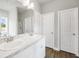 Bright bathroom featuring a double sink vanity with a marble countertop, two doors and wood grain floors at 715 Colvin Dr, Locust Grove, GA 30248