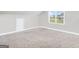 Spacious bonus room with neutral carpet, a window for natural light, and a door for convenience at 715 Colvin Dr, Locust Grove, GA 30248