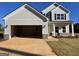 Two-story home with a large garage, gray siding, and a manicured lawn at 715 Colvin Dr, Locust Grove, GA 30248