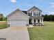 Charming two-story home featuring a two-car garage and beautiful lawn at 715 Colvin Dr, Locust Grove, GA 30248