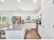 Open kitchen features white cabinets, granite countertops, stainless appliances, a kitchen island, and wood-look floors at 715 Colvin Dr, Locust Grove, GA 30248