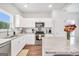 Bright kitchen features white cabinets, stainless steel appliances, granite countertops, and wood-look floors at 715 Colvin Dr, Locust Grove, GA 30248
