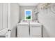 Convenient laundry room with modern appliances, a window, and shelving for storage and organization at 715 Colvin Dr, Locust Grove, GA 30248