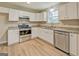 Clean kitchen with white cabinets, stainless steel appliances, and wood-look laminate flooring at 126 Usher Ln, Covington, GA 30016