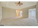 Large living room with neutral carpet and walls, offering views of the kitchen and dining areas at 126 Usher Ln, Covington, GA 30016