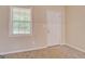 Bright room with plush carpeting, a window with blinds, and a white door at 126 Usher Ln, Covington, GA 30016