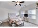 Cozy bedroom with a decorative headboard, bench, ceiling fan, and plenty of natural light from windows at 1721 Mcgarity Rd, Temple, GA 30179