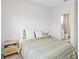 A serene bedroom featuring a bed with light green striped coverlet and a glimpse of an attached bathroom at 3460 Sycamore Sw Dr, South Fulton, GA 30331