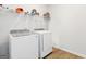 Laundry room featuring a modern washer and dryer set with wire rack shelving above, plus wood-look floors at 3460 Sycamore Sw Dr, South Fulton, GA 30331