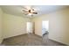 Spacious carpeted bedroom with a ceiling fan and a view into an adjoining bathroom at 416 Clarion Dr, Carrollton, GA 30116