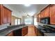 This kitchen has stone countertops, stainless appliances, wooden cabinetry, and hardwood floors at 416 Clarion Dr, Carrollton, GA 30116