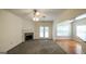 Cozy living room with a stone fireplace, ceiling fan and access to the backyard through glass doors at 416 Clarion Dr, Carrollton, GA 30116