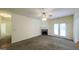 Cozy living room with a stone fireplace, ceiling fan, and access to a room with hardwood flooring at 416 Clarion Dr, Carrollton, GA 30116