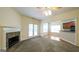 Spacious living room featuring a fireplace, ceiling fan and an opening into the kitchen area at 416 Clarion Dr, Carrollton, GA 30116