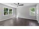 An open bedroom with hardwood floors, large windows, and a ceiling fan at 985 Columbia Dr, Decatur, GA 30030