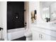 Modern bathroom boasts black tile shower, white vanity with gold fixtures and unique artwork at 104 Meldon Se Ave, Atlanta, GA 30315
