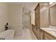 Bathroom with double vanity, stone counters, a soaking tub, and a glass-enclosed shower at 1006 Fendley St, Woodstock, GA 30188