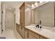 Bathroom featuring a double vanity with stone counters, wood cabinets, and a soaking tub at 1006 Fendley St, Woodstock, GA 30188