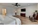 Spacious bedroom with hardwood floors, ceiling fan, TV and hallway access at 1006 Fendley St, Woodstock, GA 30188