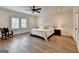 Spacious primary bedroom with a ceiling fan, hardwood floors and large windows at 1006 Fendley St, Woodstock, GA 30188