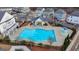 A swimming pool with a modern clubhouse, a splash pad and landscaping, surrounded by homes in a community at 1006 Fendley St, Woodstock, GA 30188