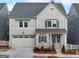 Charming two-story home with a front-facing garage, beautifully landscaped yard, and craftsman style windows at 1006 Fendley St, Woodstock, GA 30188