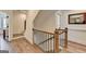 Open hallway with wooden banister, hardwood floors, and natural lighting with multiple doorways at 1006 Fendley St, Woodstock, GA 30188