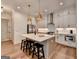 Bright white kitchen features a large island with seating and modern stainless steel appliances and fixtures at 1006 Fendley St, Woodstock, GA 30188