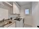 Modern laundry room with stainless steel sink, front load washer/dryer and white cabinets at 1006 Fendley St, Woodstock, GA 30188