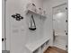 Bright mudroom with built-in bench, storage cubbies, coat hooks, and access to a tiled bathroom at 1006 Fendley St, Woodstock, GA 30188